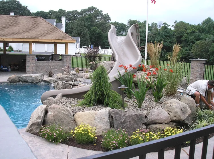 Custom inground pool with natural rock waterfall and slide installed by Gorlin Pools and Spas in Lakehurst NJ