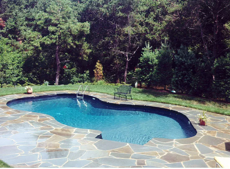 Freeform vinyl liner pool with flagstone patio deck installed by Gorlin Pools and Spas in Lakehurst NJ