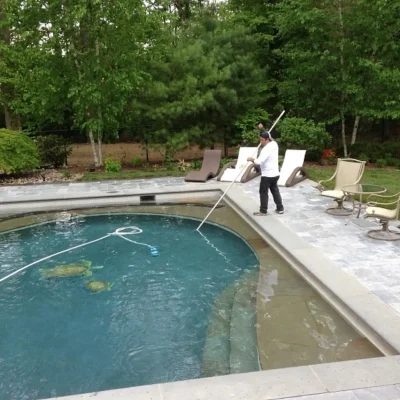 technician-cleaning-pool-with-pole